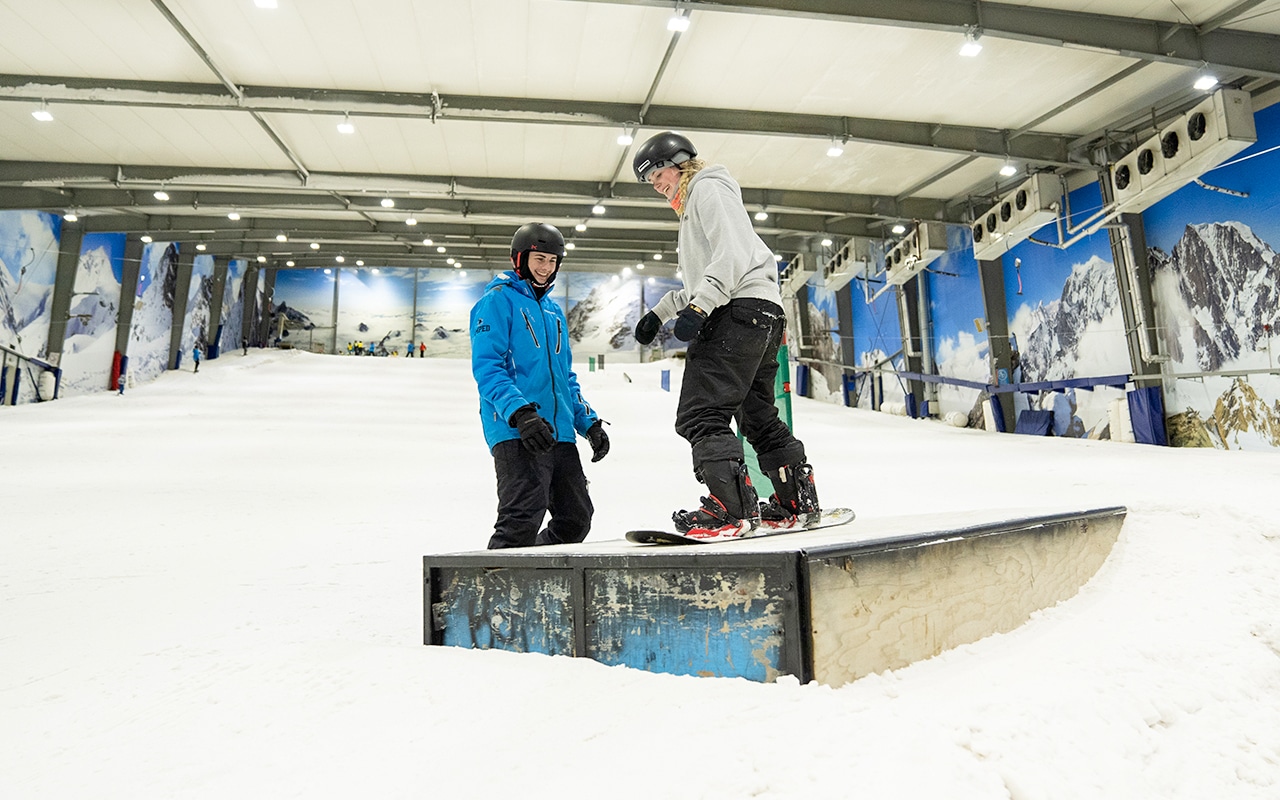 Instructor teaching snowboarder in the Terrain Park