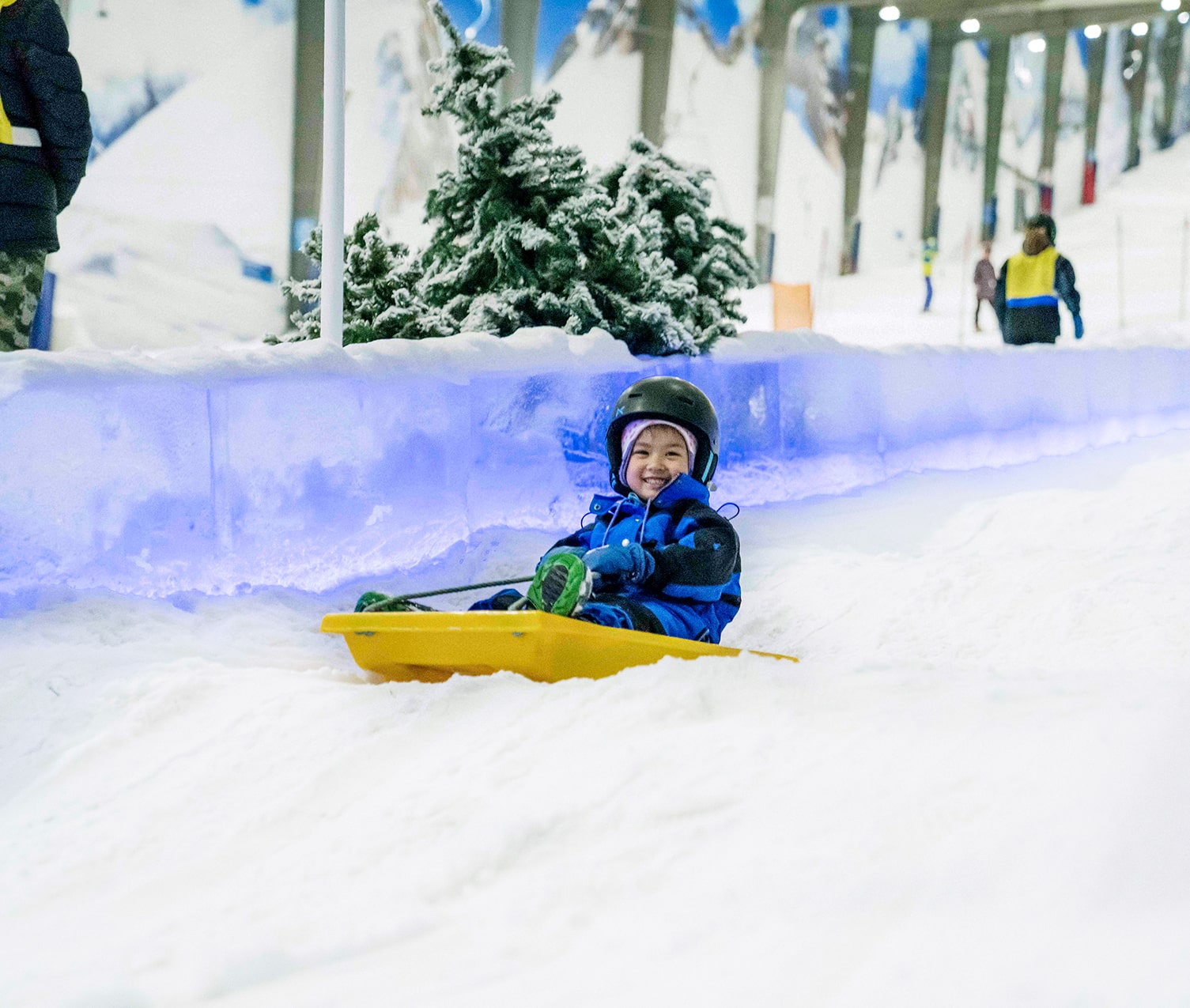 Kindy kid riding a toboggan at Snowplanet