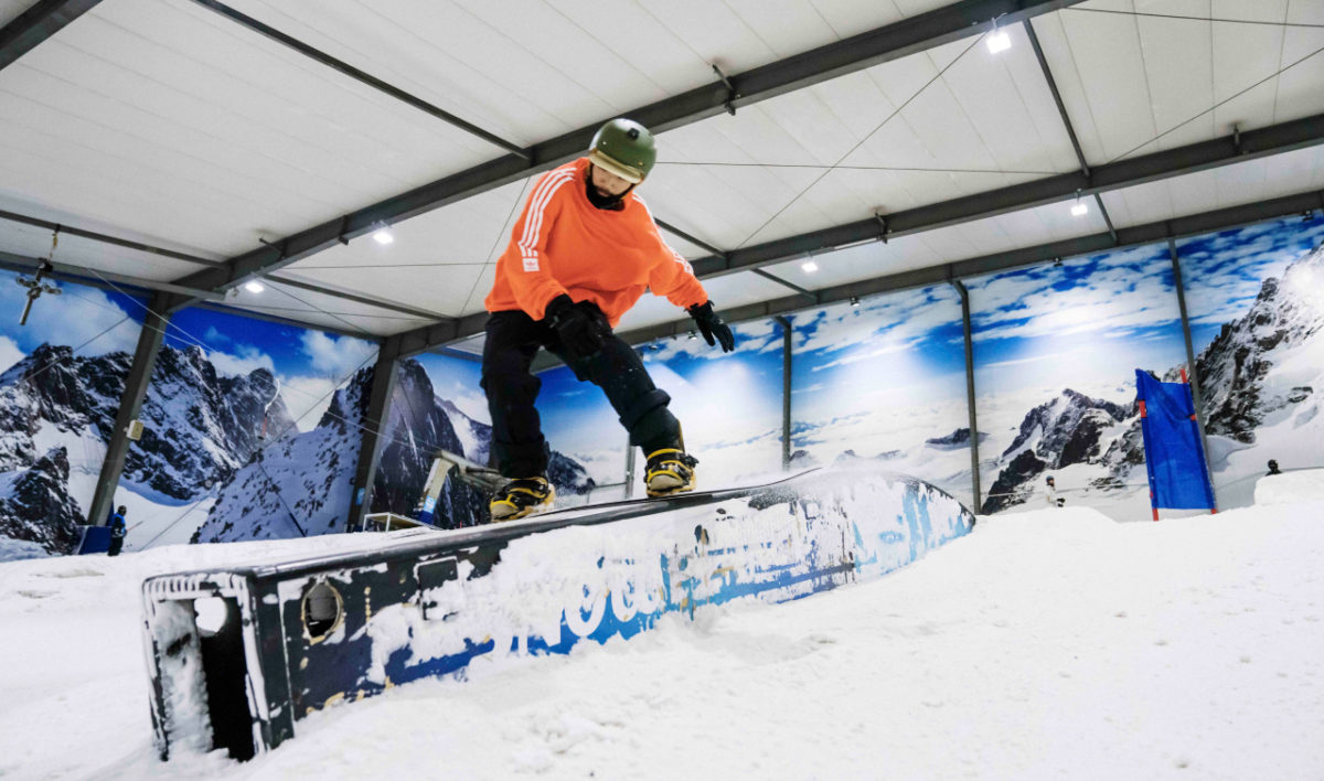 Snowboarder riding terrain park at night in Auckland's Snowplanet