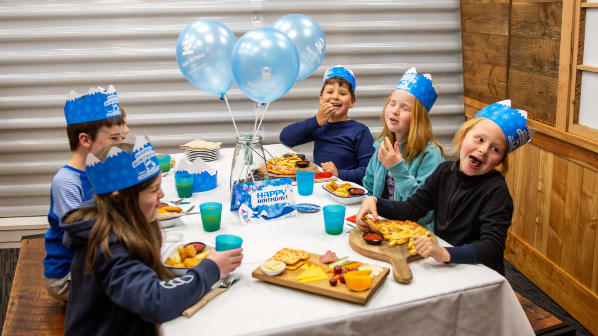 Kids eating at a birthday party in Snowplanets party rooms