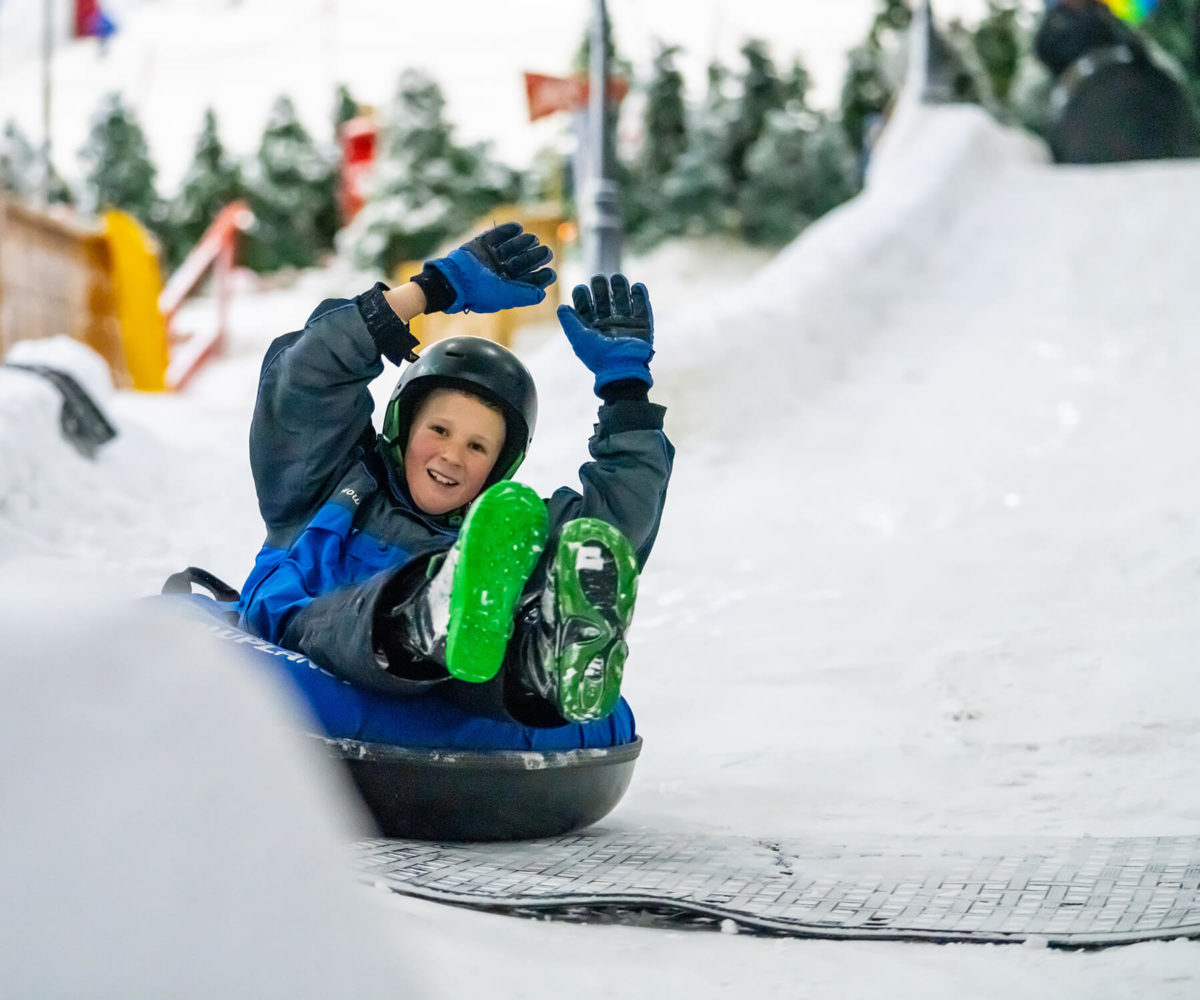 School boy snow tubing at Winter Wonderland on Snowplanet