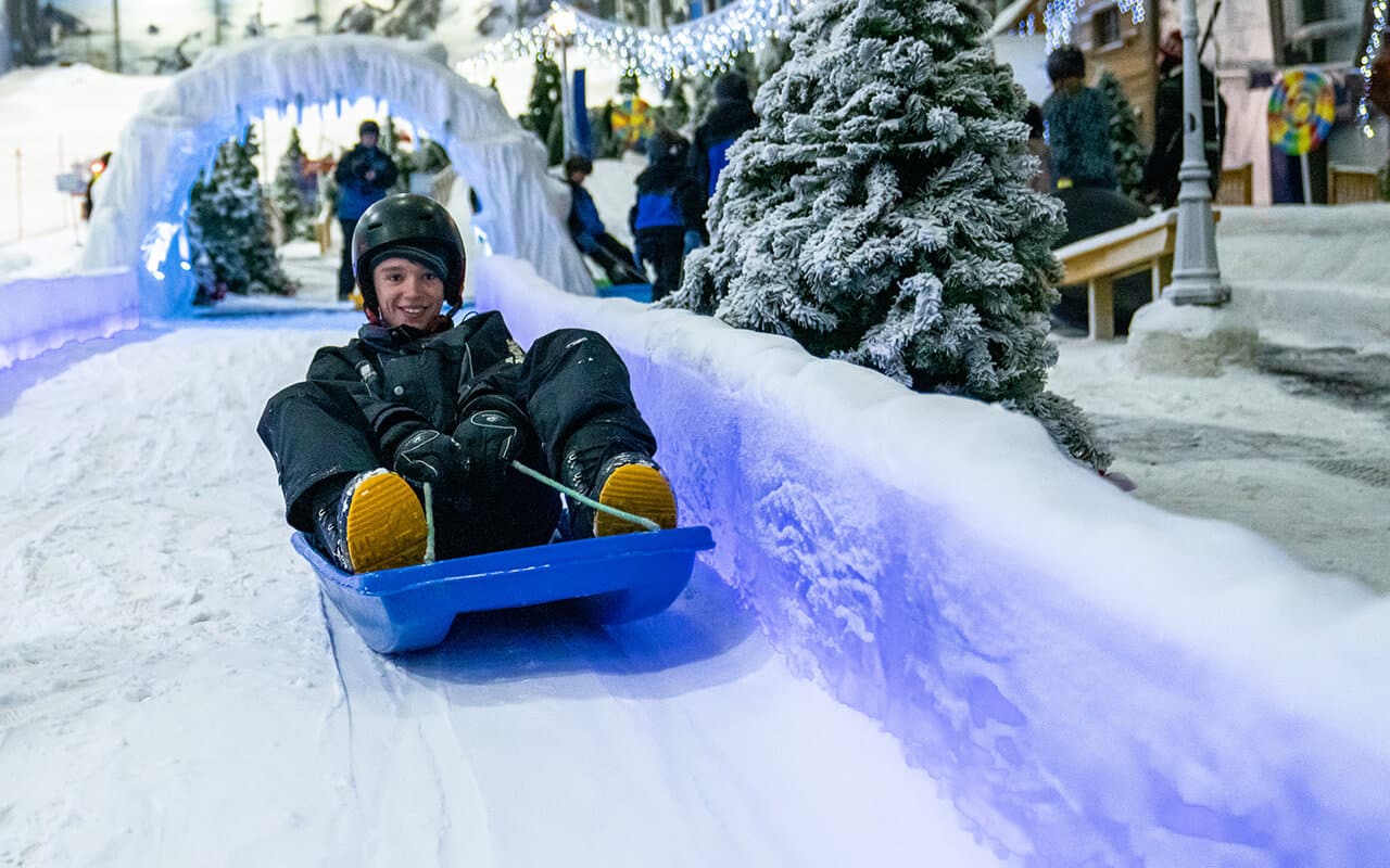 Boy riding a toboggan at Snowplanet in Winter Wonderland
