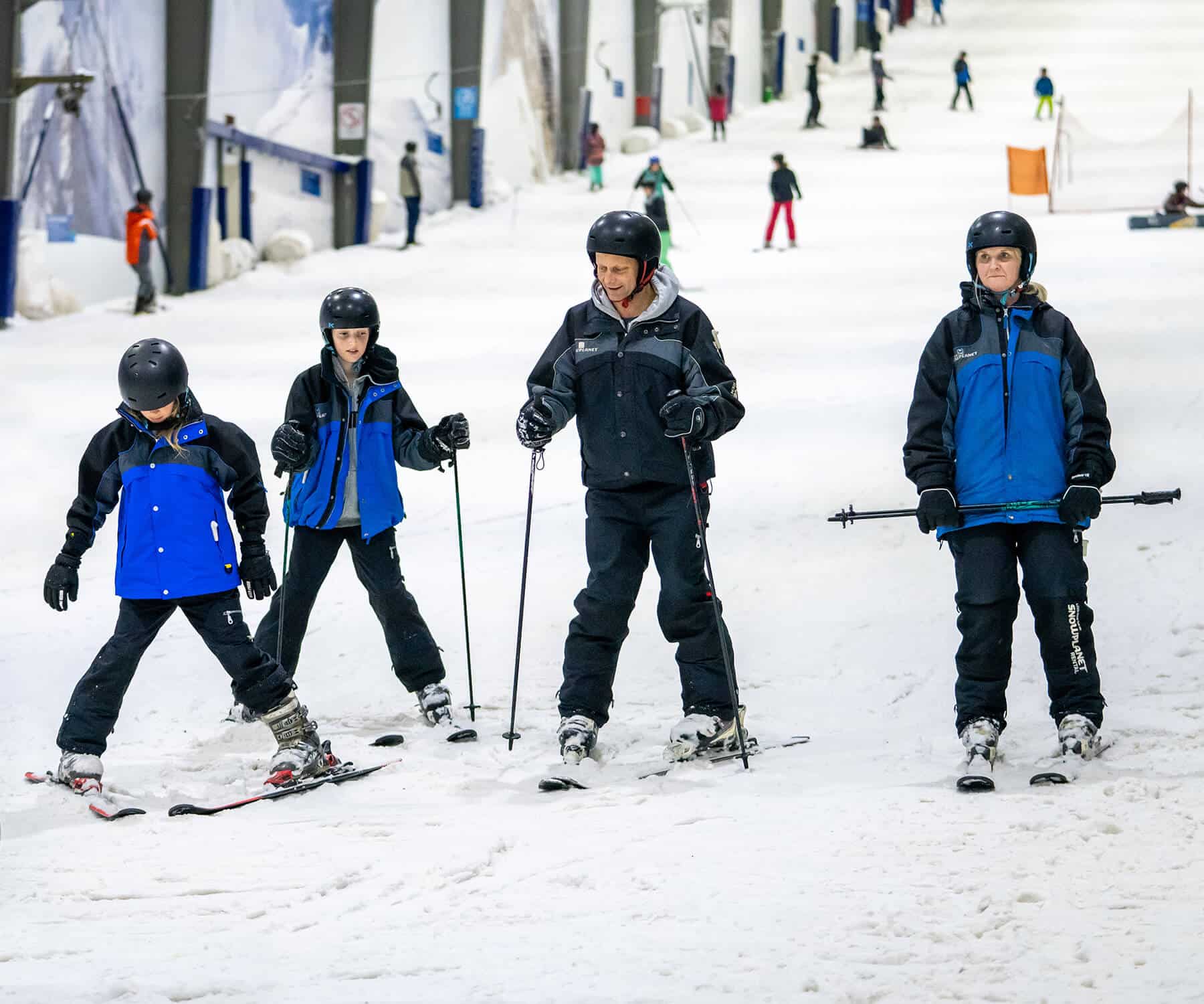 Happy family skiing on Beginner's Slope at Snowplanet