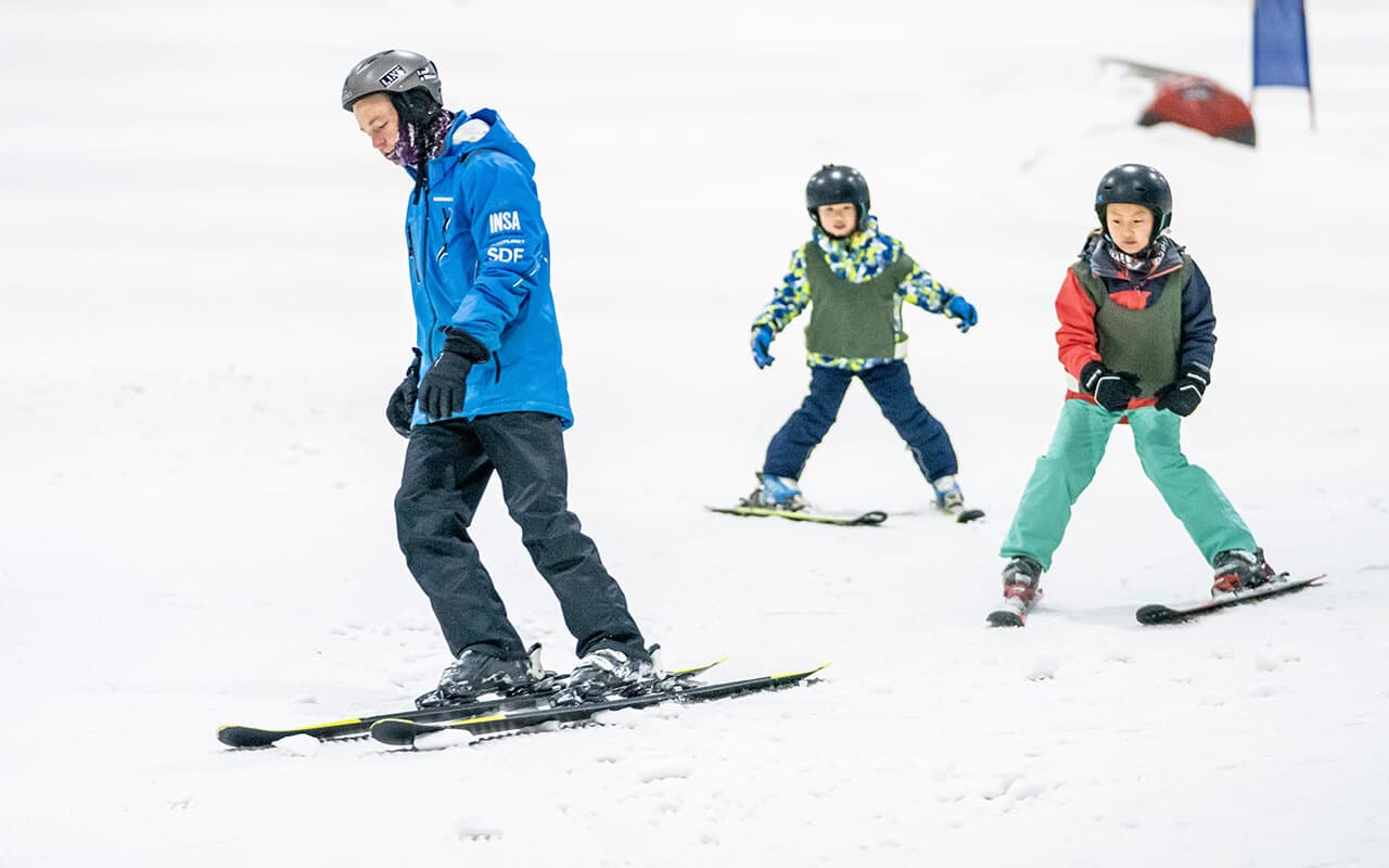 Two children getting a ski lesson at Snowplanet