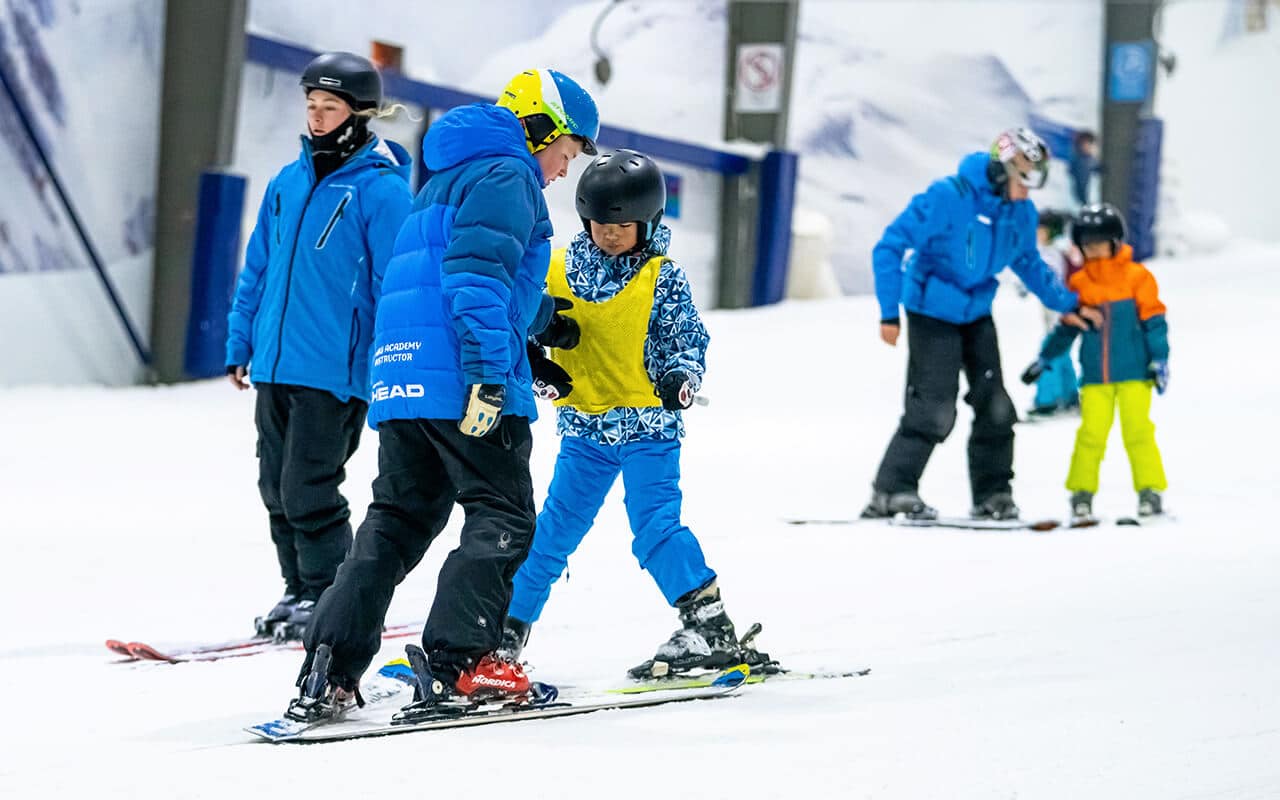 Ski instructor teaching a child to ski in a one on one ski lesson